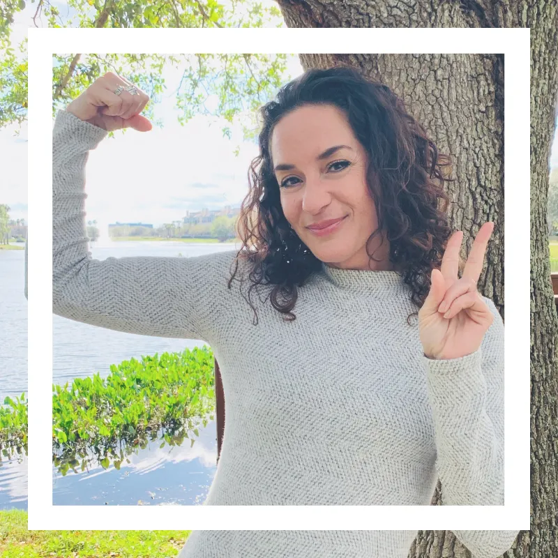 Coach Barb of b•great Coaching, smiling with strength and peace by a lakeside tree—empowering women with chronic illness to reclaim energy and confidence.