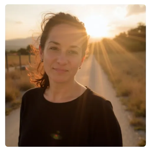 Woman smiling outdoors radiating with one arm flexed and the other showing a peace sign—symbolizing strength, confidence, calm and joyful resilience.