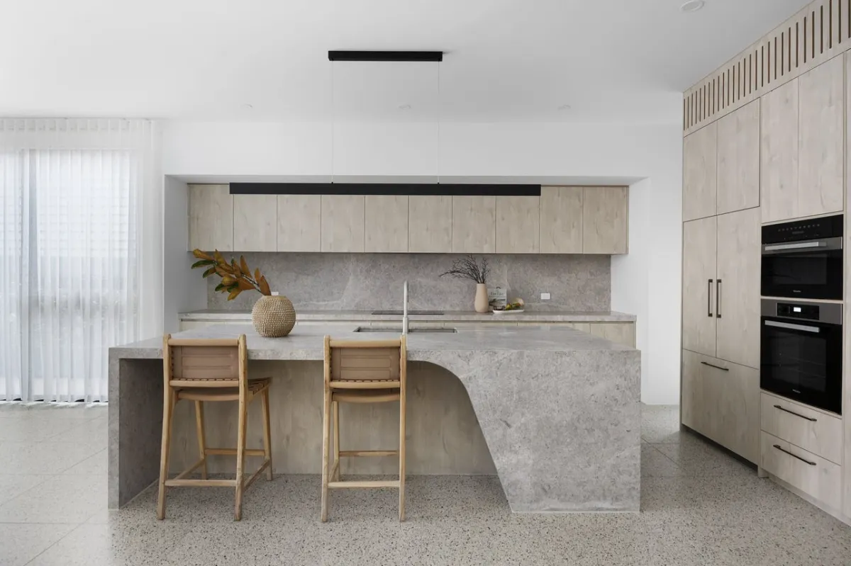 Bright, renovated open-plan living space with neutral tones and natural light