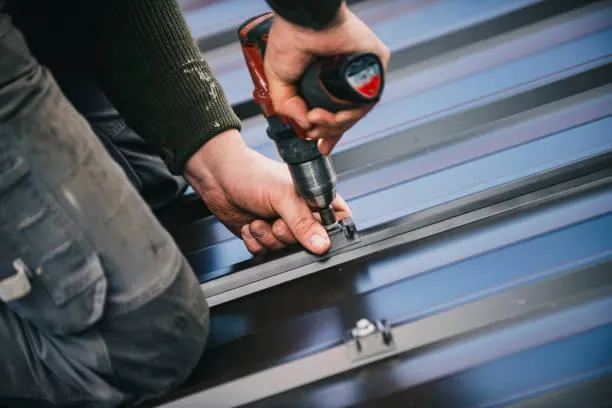 Skilled roofer securing a metal roof panel in place, demonstrating precision and expertise in metal roofing installation