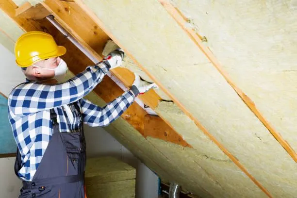 Professional from Home Star Roofing performing air sealing in an attic to enhance home energy efficiency.