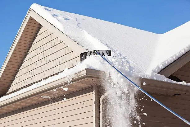 Residential home in winter showcasing the effectiveness of Home Star Roofing's snow removal service on a pitched roof.