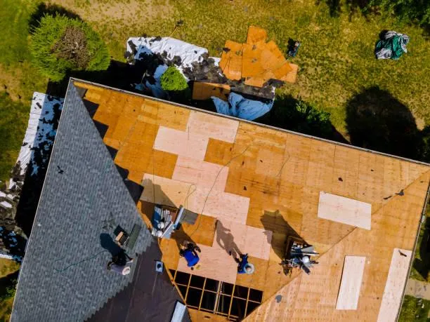 Aerial view of a roofing crew performing extensive repairs on a large roof, underlining Home Star Roofing's commitment to protecting your investment.