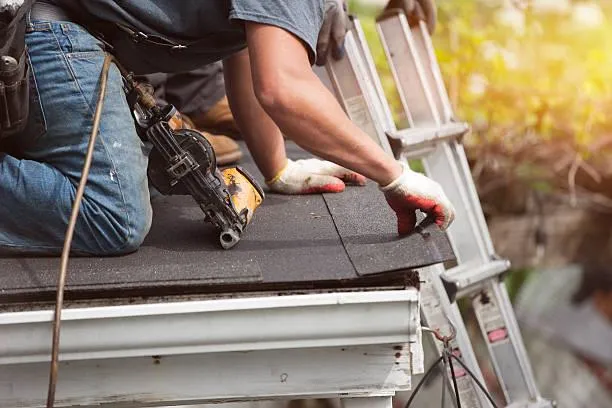 Roofer applying sealant to roof shingles, showcasing the expertise of Home Star Roofing's repair services.