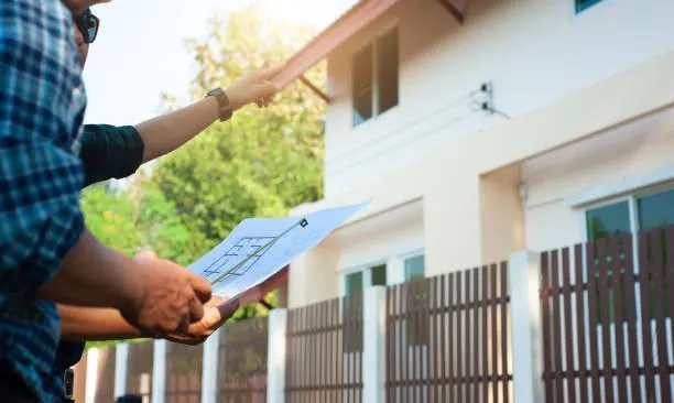 Roof consultant holding clipboard on commercial property, representing Home Star Roofing's professional maintenance assessment.