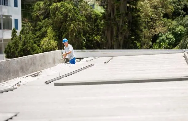 Roof consultant inspecting a commercial flat roof, part of Home Star Roofing's consulting services to maximize performance.