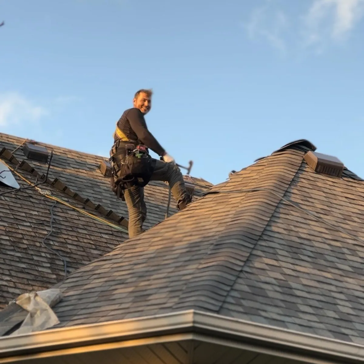 Roofer working on a residential roof at sunset, reflecting the hands-on expertise of Home Star Roofing's professional team.