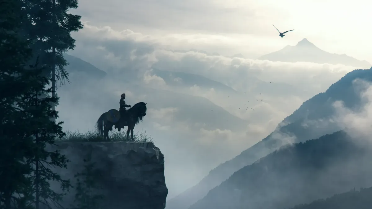 person on horseback looking out over a misty mountain