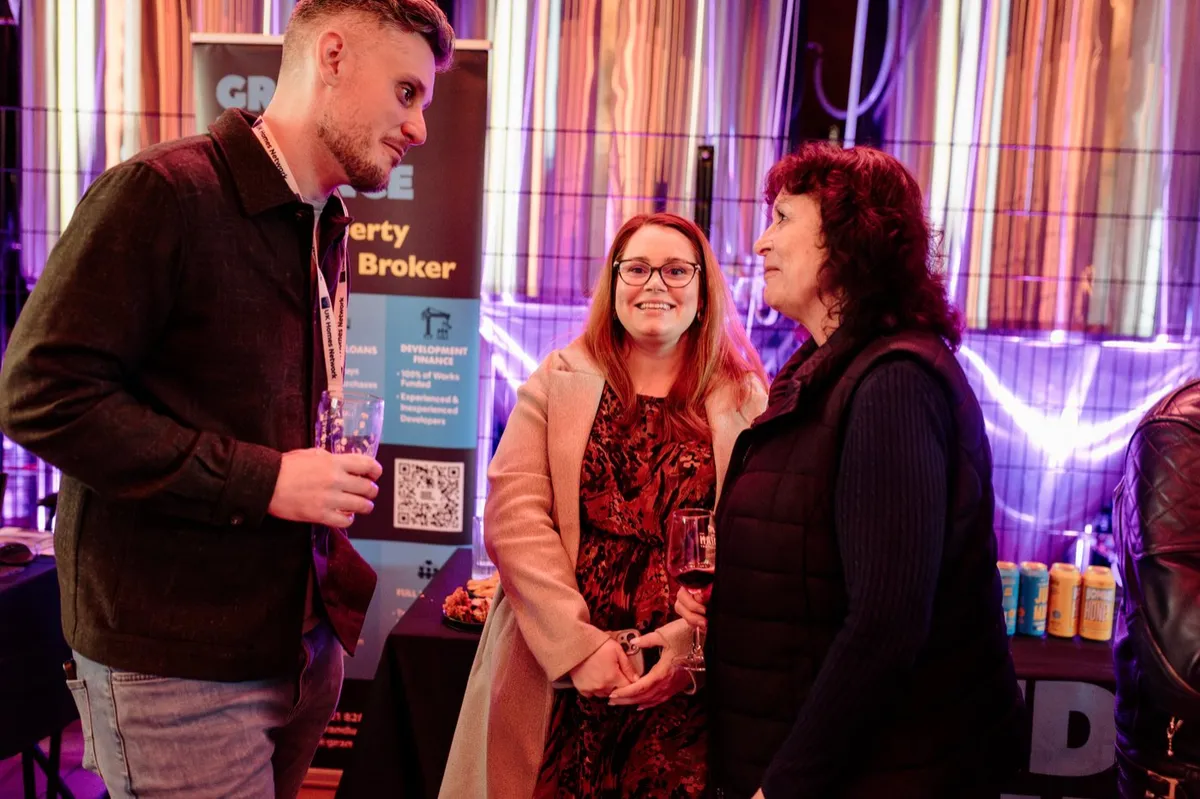 Three guests in conversation under the brewery lights at UK Homes Network LIVE Birmingham, February 2026