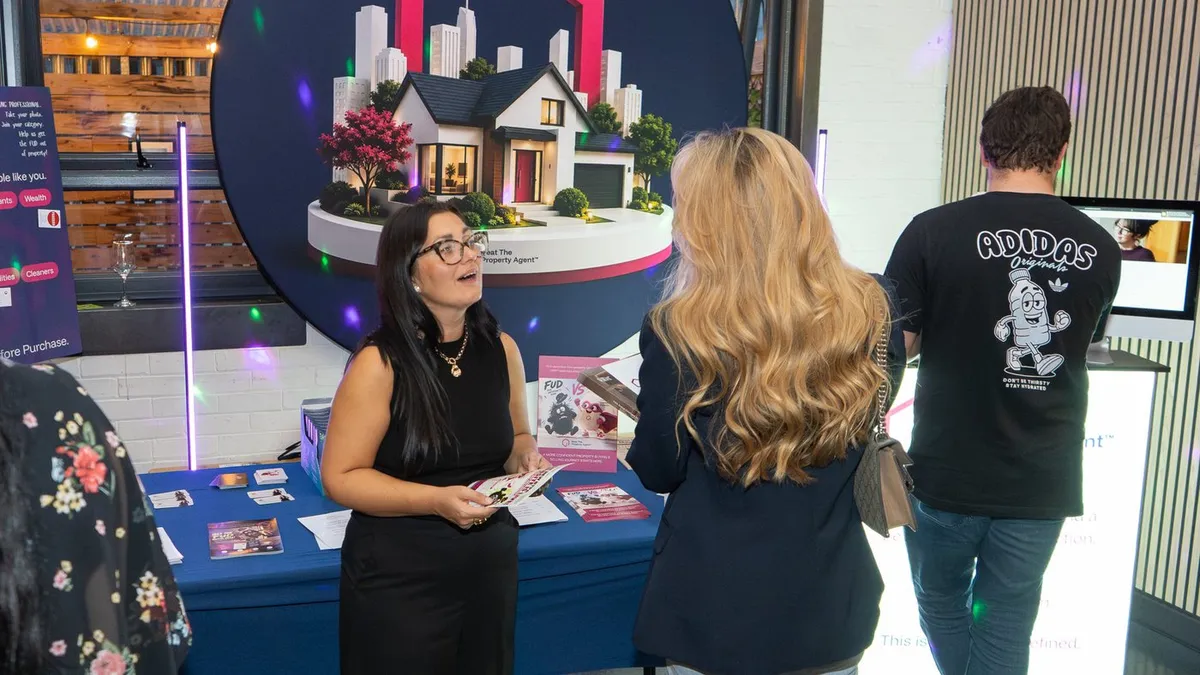 An exhibitor talking to visitors at her stand at UK Homes Network LIVE Leeds