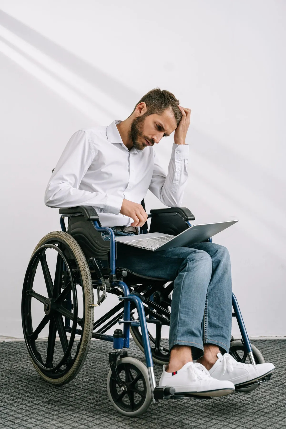 Man in a wheelchair using a laptop to browse a website