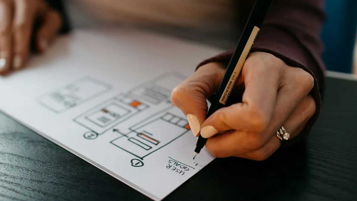 Hand sketching a website page layout on paper before design starts