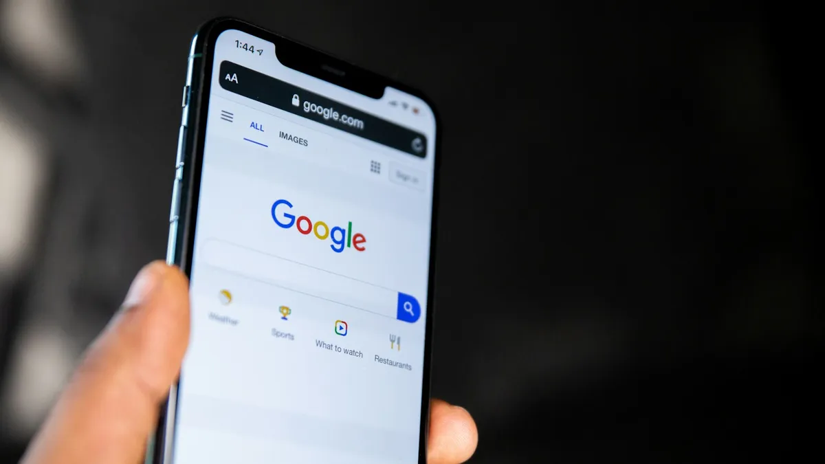 Phone in a hand showing the Google search page