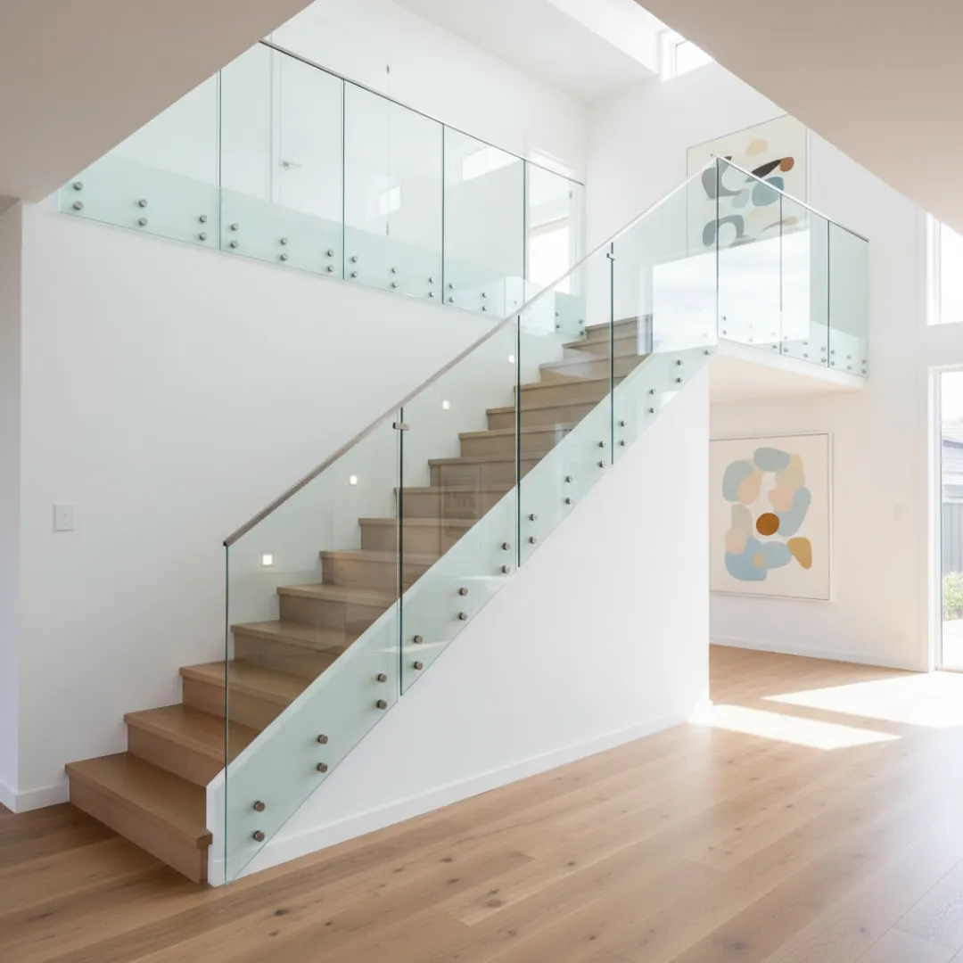 Pin‑fixed standoff glass balustrade side‑mounted to the stairs for floating glass effect