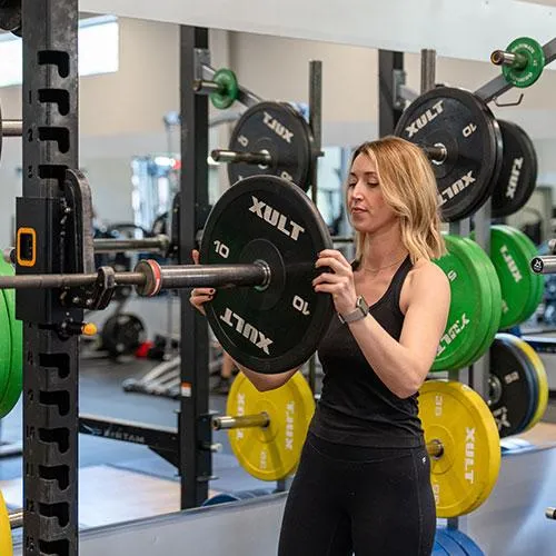 Woman racking weights on barbell