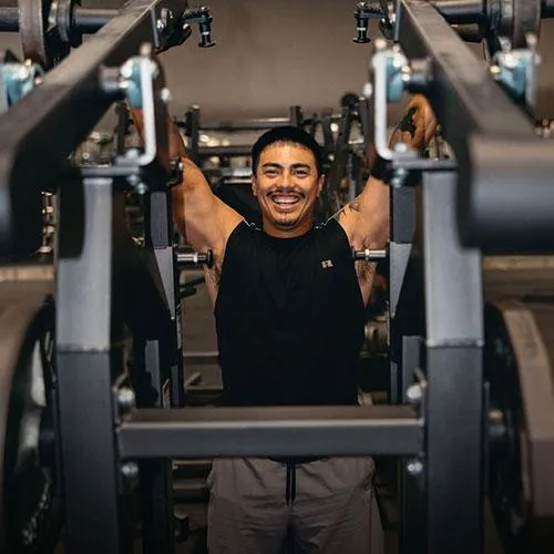 man on weight machine smiling