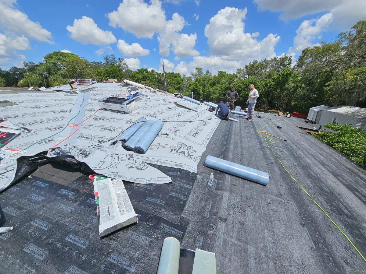 Red clay tile roof installation in progress on residential property.