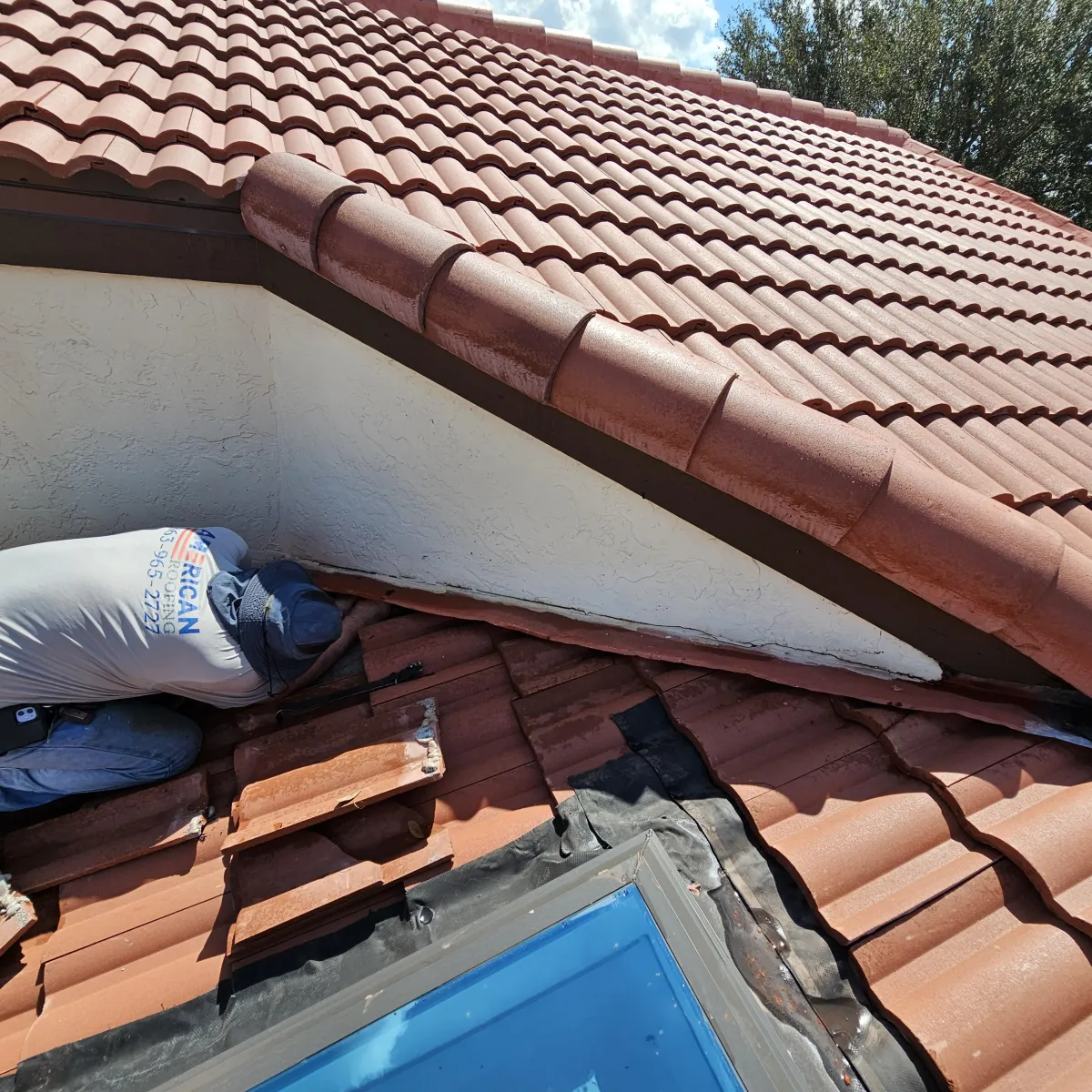 Red clay tile roof installation in progress on residential property.