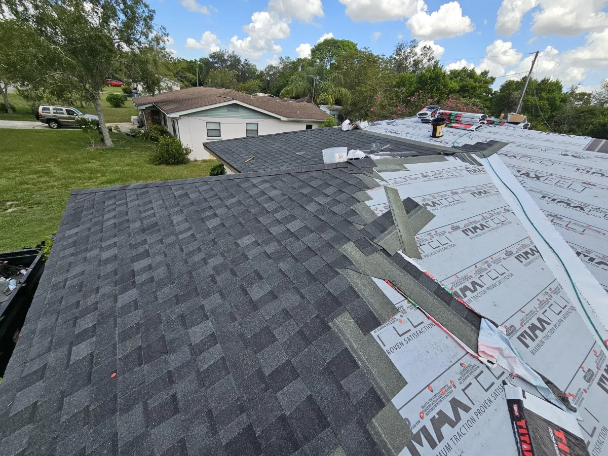 New asphalt shingle roof installation on Florida home with underlayment partially applied.