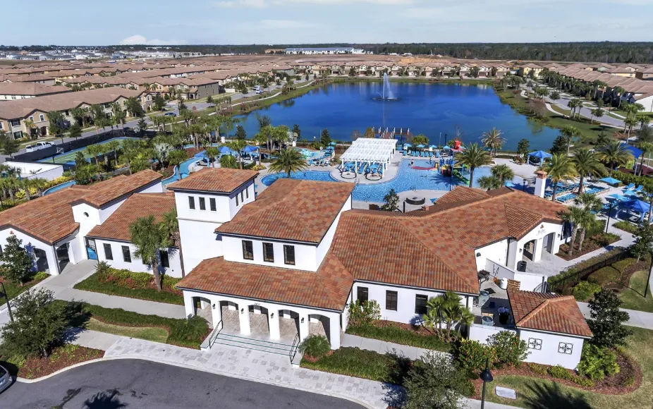 Aerial of a Davenport community—clubhouse with red tile roofs beside a large lake