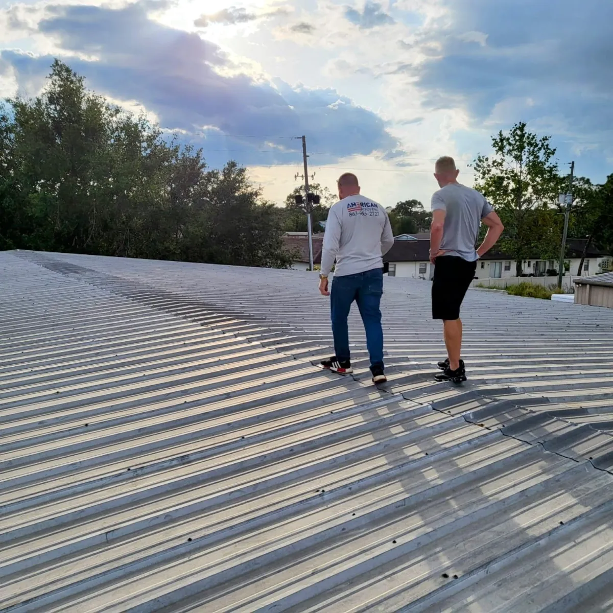 Crew walking on a standing-seam metal roof during final inspection in Polk County, FL.
