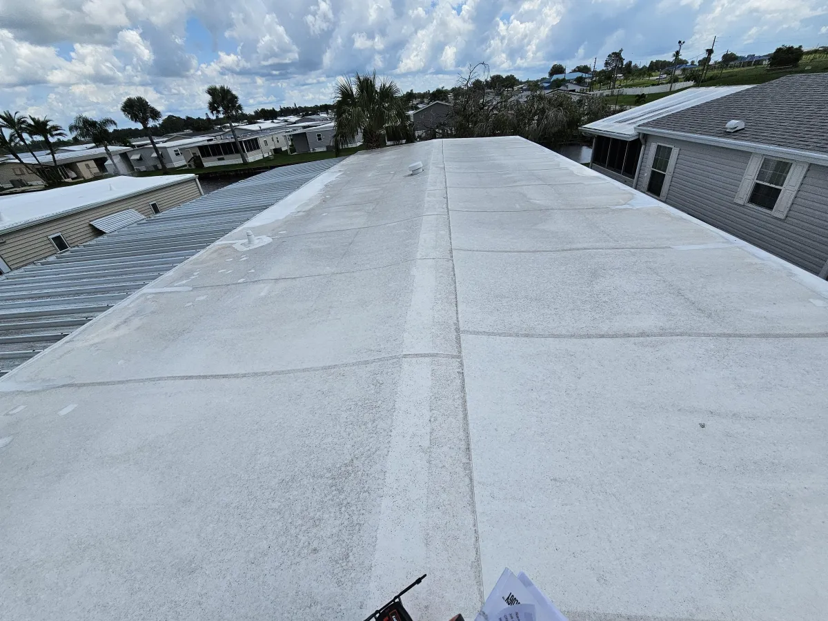 Long run of white TPO membrane on a flat roof between buildings.