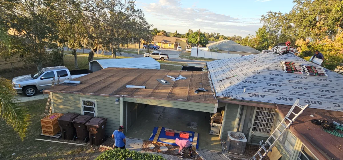 Flat roof tear-off and re-decking in progress; underlayment staged.