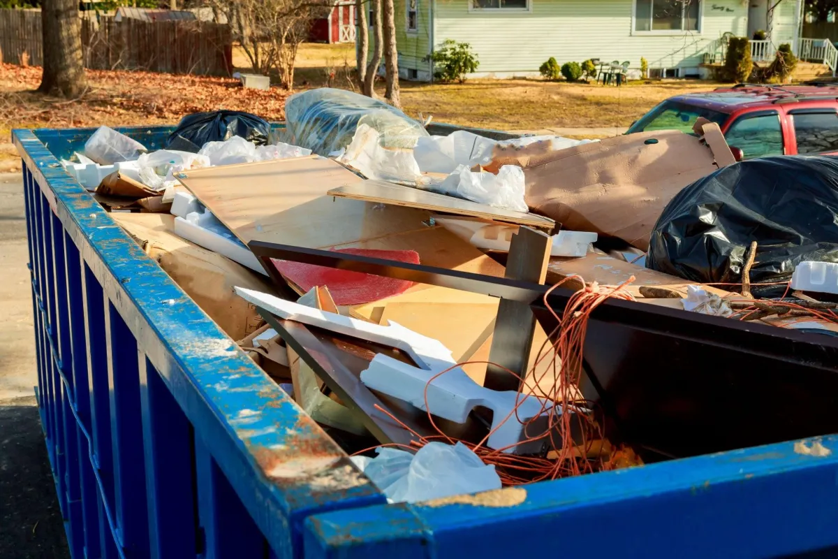 an open top dumpster full of junk