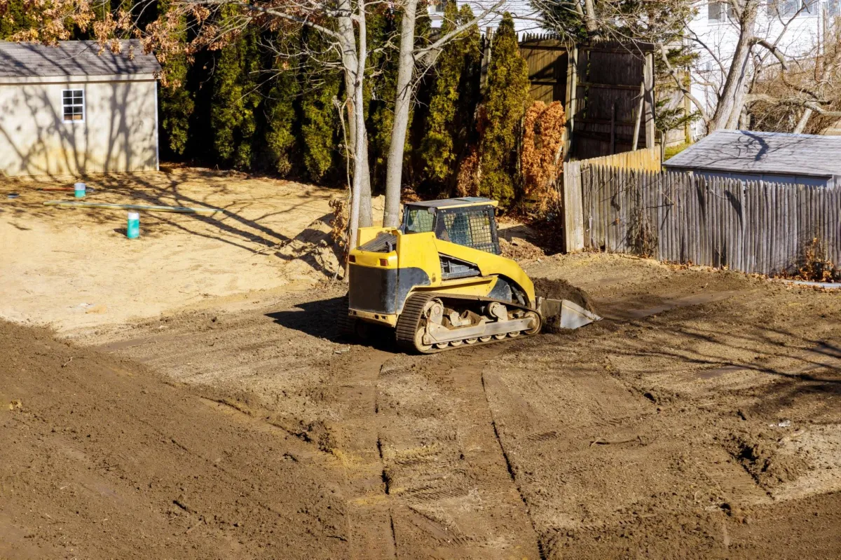 a skid steer leveling a lot