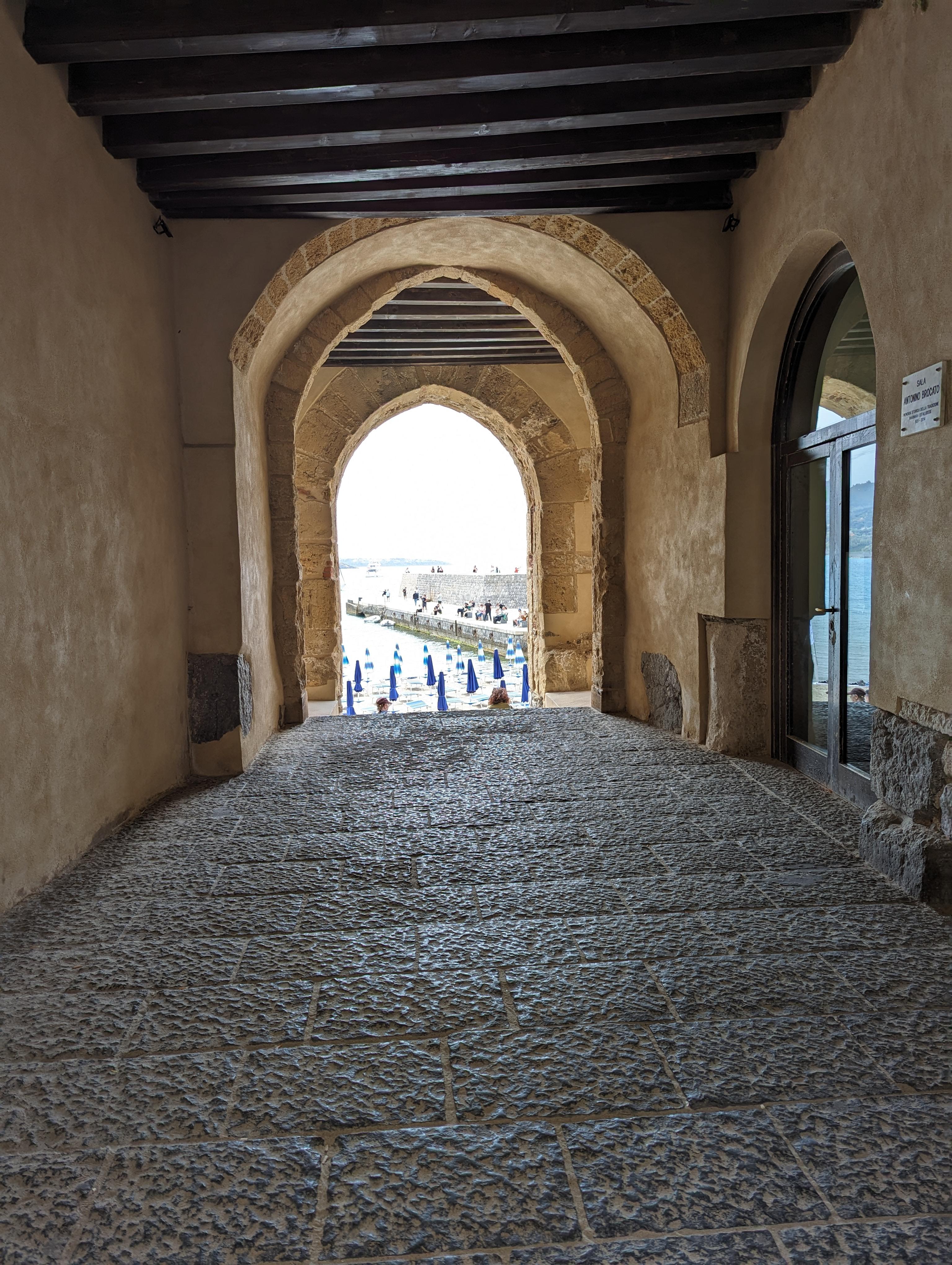 View looking from inside an old building to the beach outside. Detail is inside the doorway which is open.