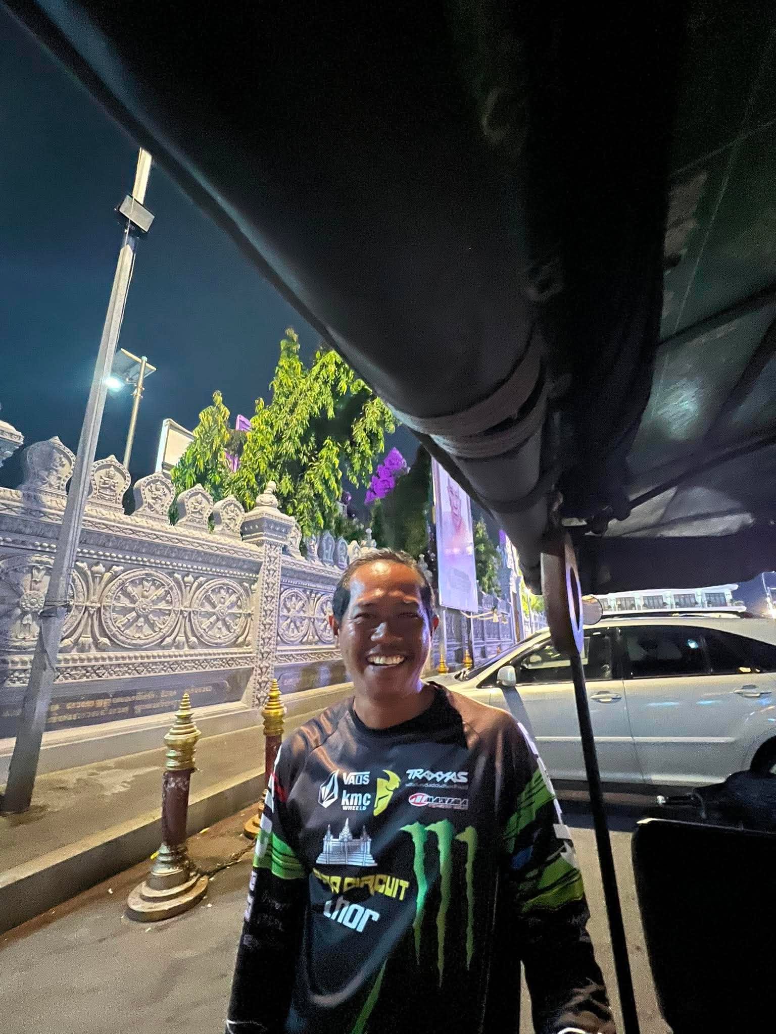 Ton smiling warmly next to his spacious tuk-tuk in Phnom Penh