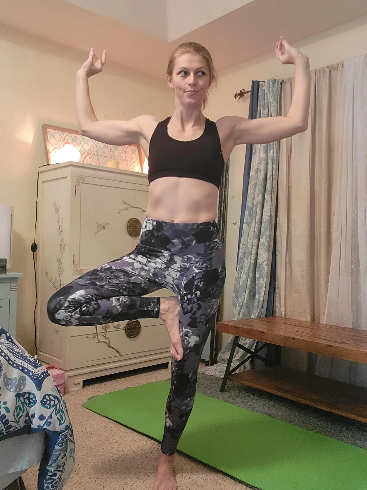 grayscale photo of woman exercising on top of large rock