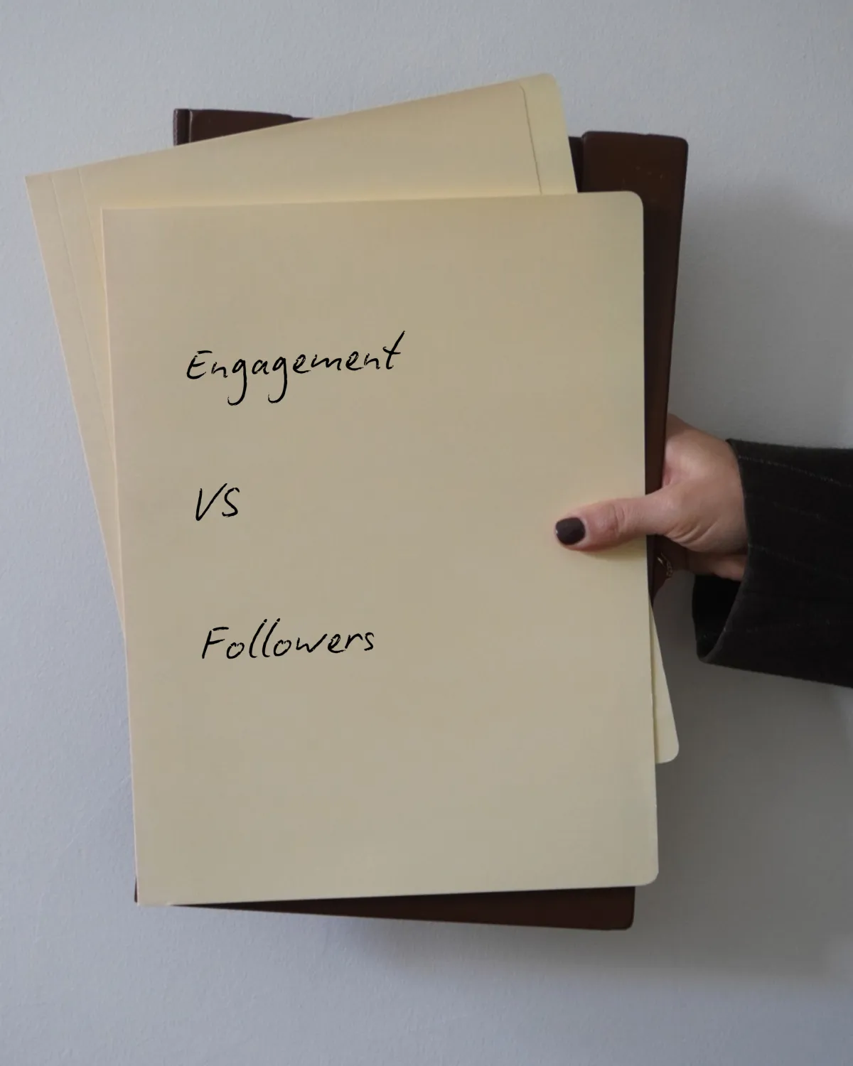 Folder in hand reading Engagement Vs Followers