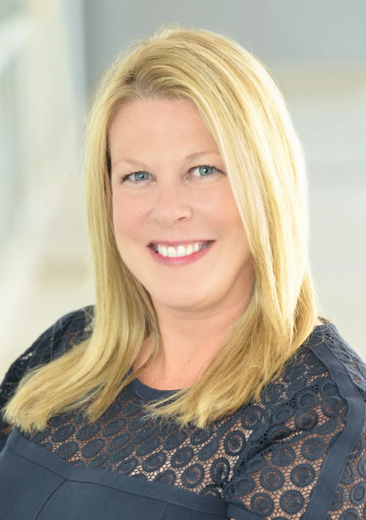 Mary Ellen Vanaken, CEO and Founder of The Mary Ellen Vanaken Team, smiling in a professional setting, showcasing her expertise in North Atlanta real estate.