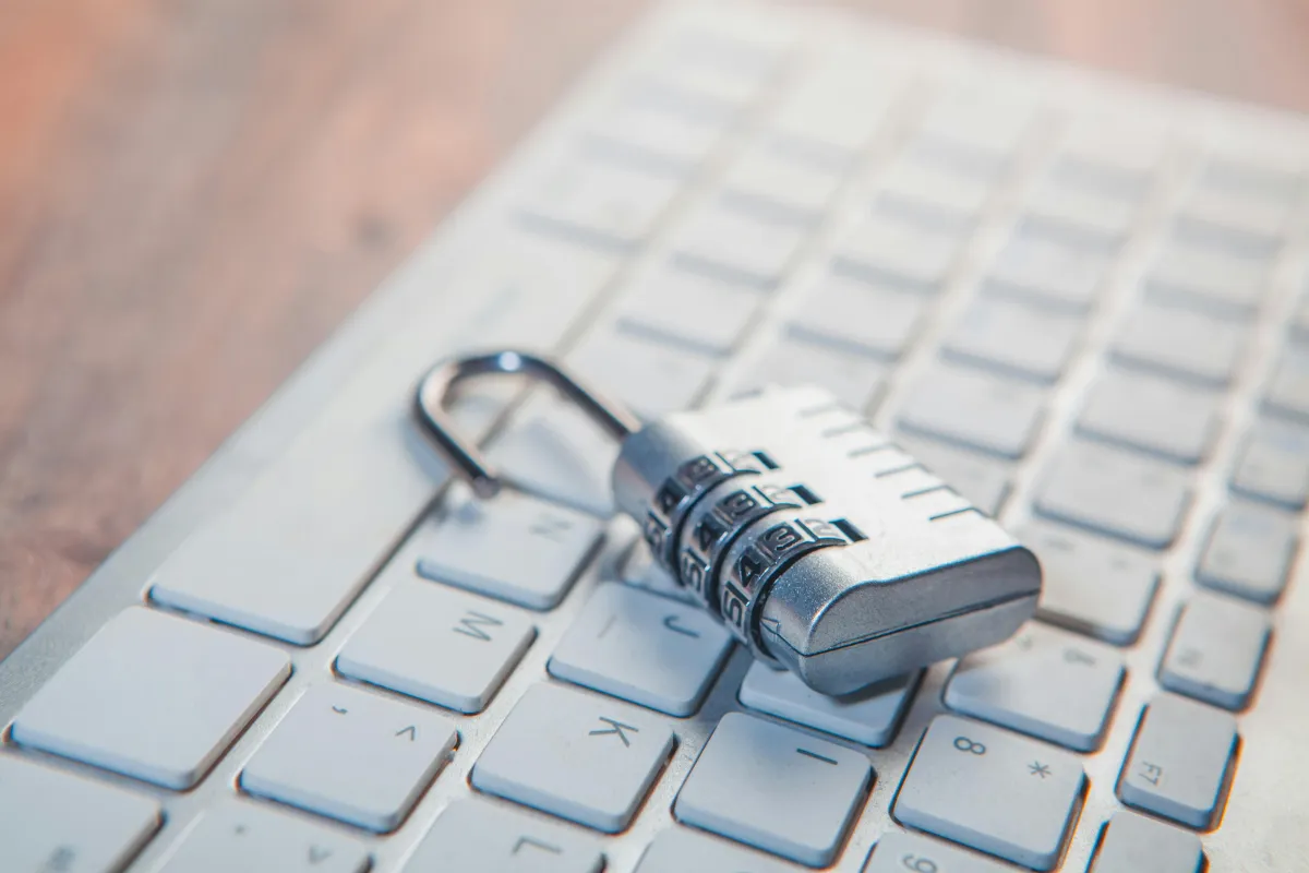 A combination padlock resting on a computer keyboard, symbolizing cybersecurity and data protection.
