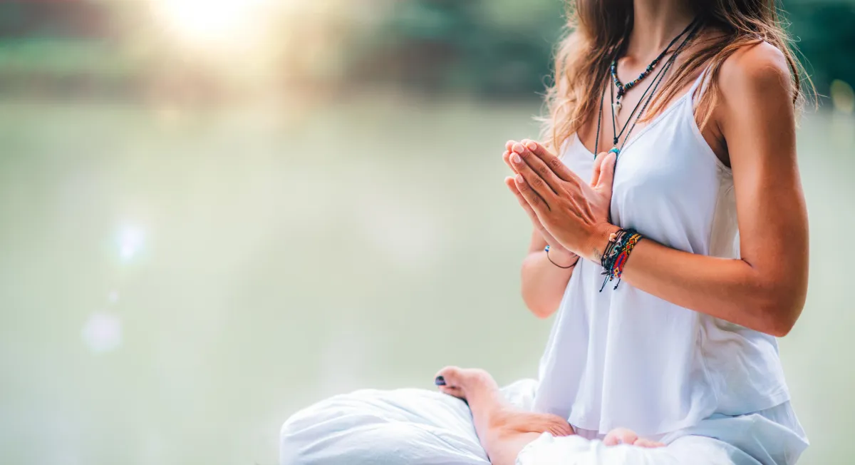 woman with hands on heart in meditation postion