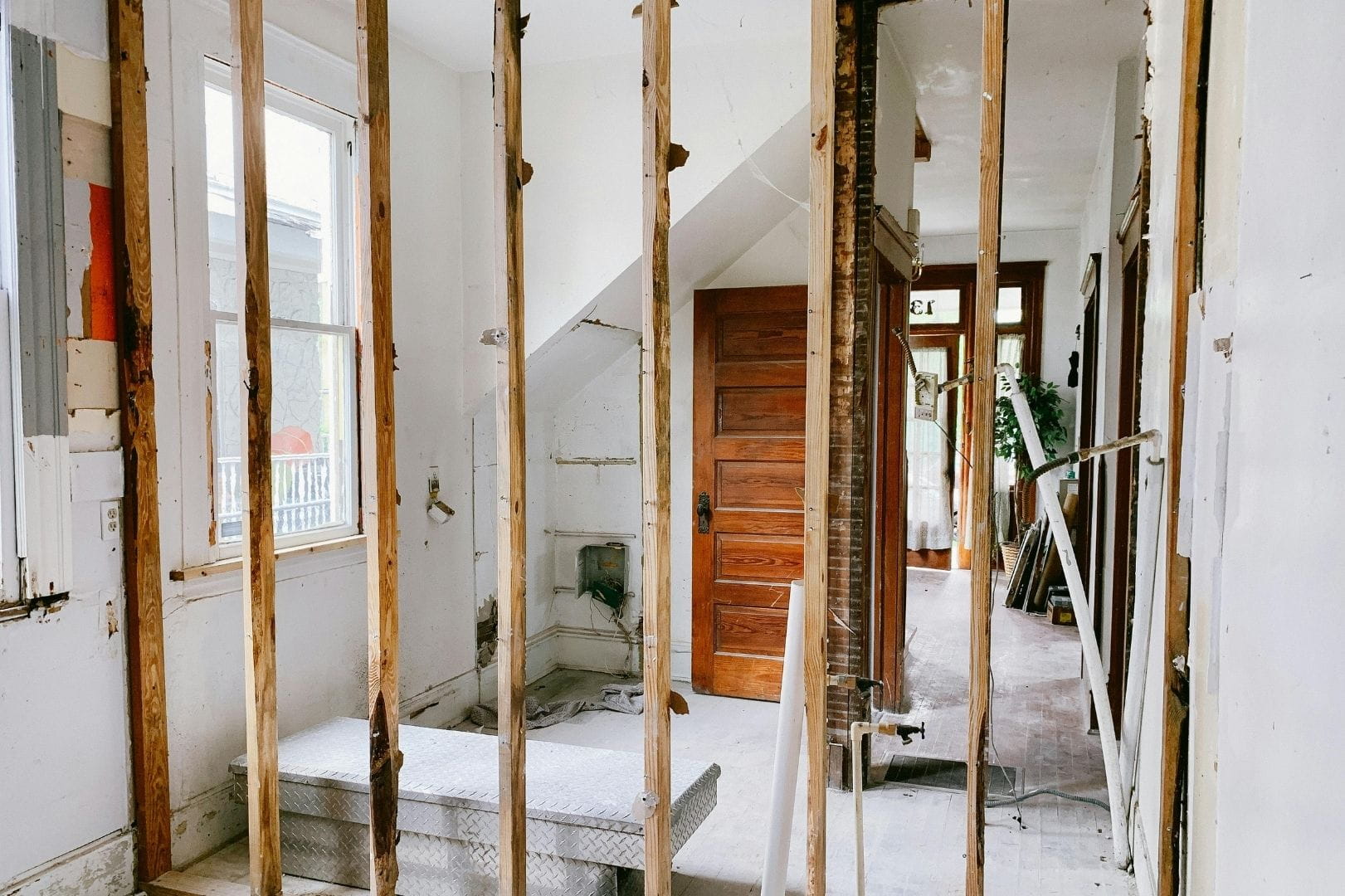 Vue intérieure d'une maison en cours de rénovation structurelle avec mise à nu des cloisons et des poutres.