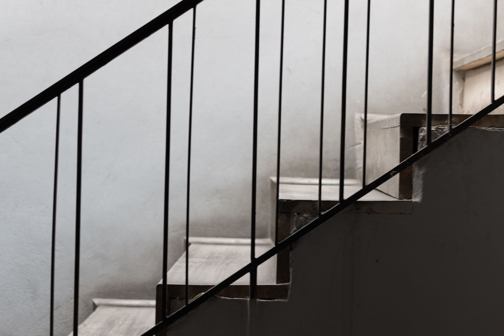 Installation d'un garde-corps de sécurité en métal noir avec barreaudage vertical sur un escalier extérieur.