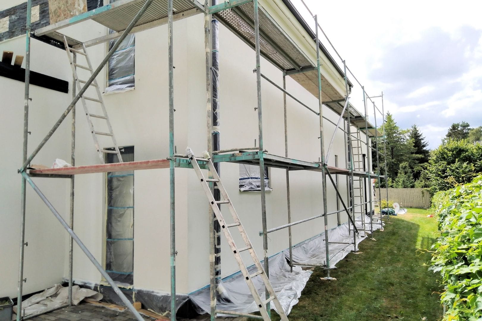 Artisan façadier en plein travail de ravalement et finition sur un mur extérieur à Dreux