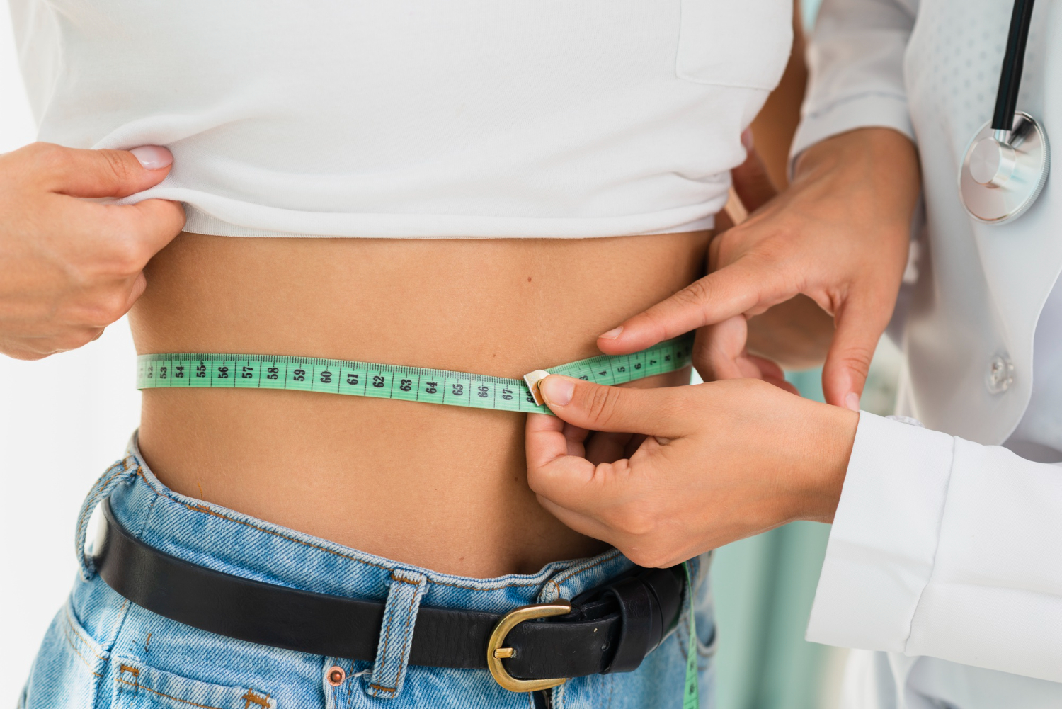 Close-up doctor measuring woman's abdomen