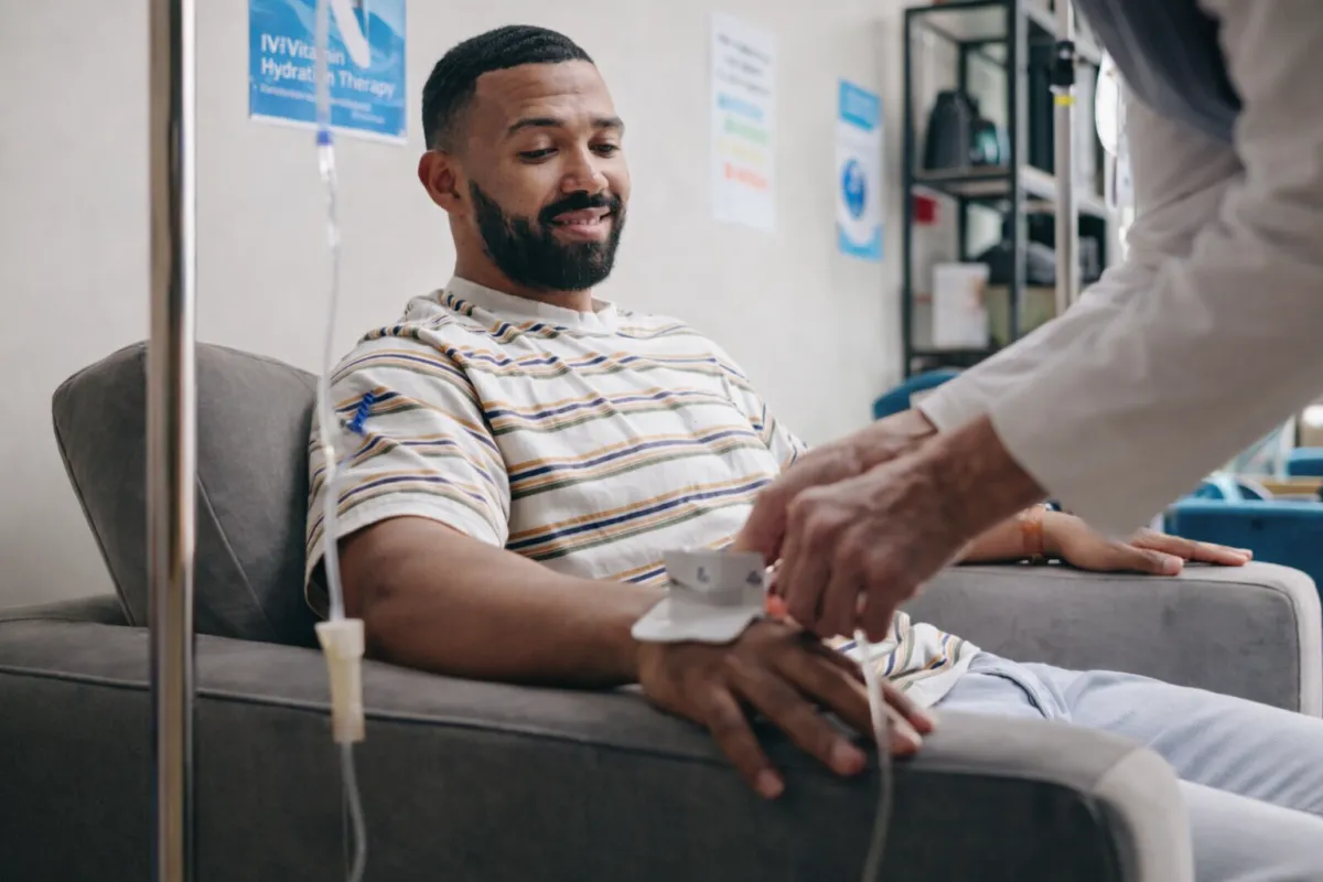 A man sitting on a clinic having an IV therapy session