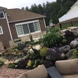 Residential landscape design with flowers, plants, and decorative stone