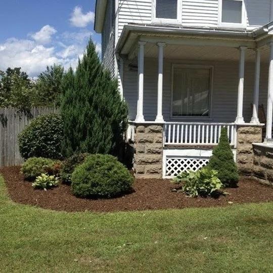 Fresh mulch and shrub landscaping around a residential front porch