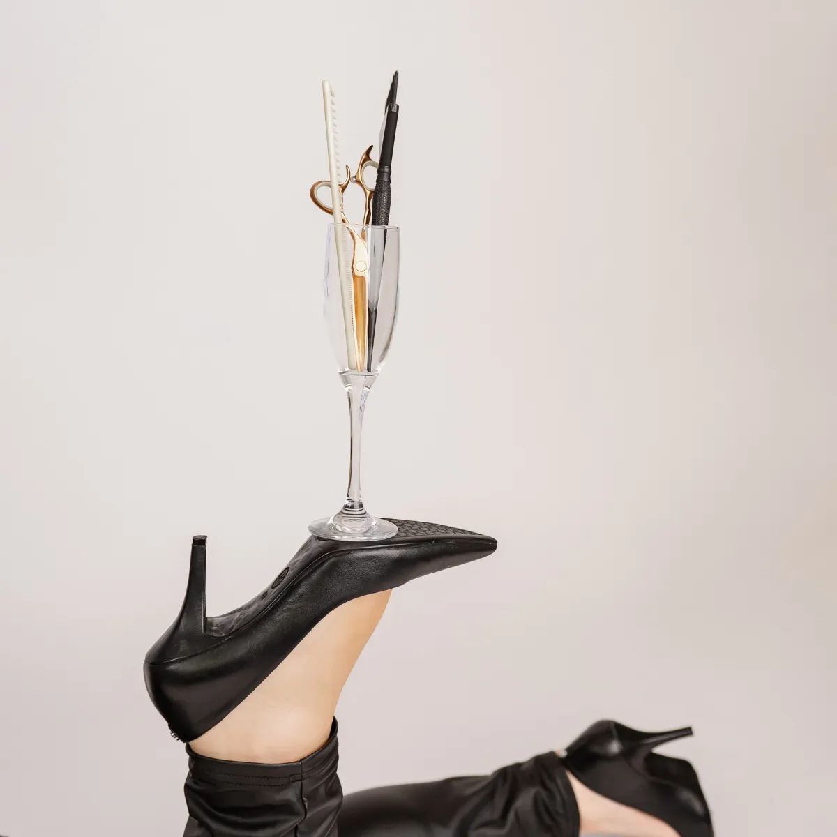 Elegant high-heel shoe with beauty tools, representing dimensional color artistry and refined hair design