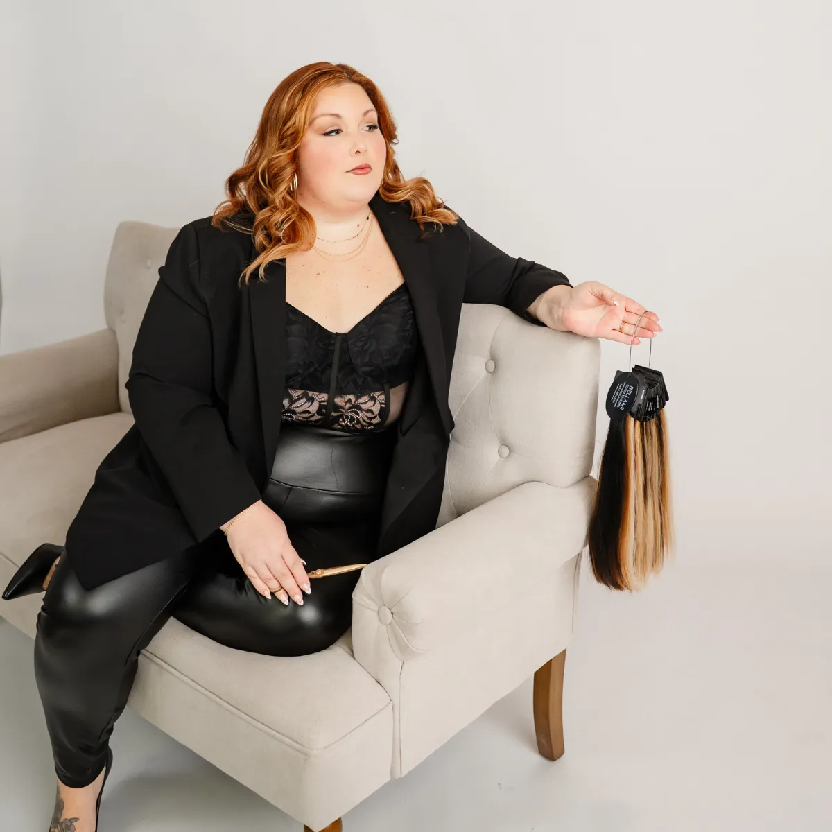 Client wearing long, full luxury weft hair extensions styled seamlessly inside a luxury salon studio