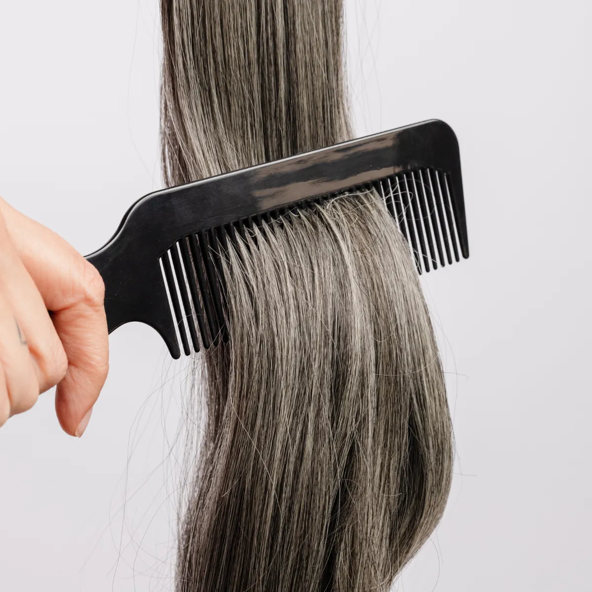 thinning hair being sectioned with a comb showing crown thinning and density loss