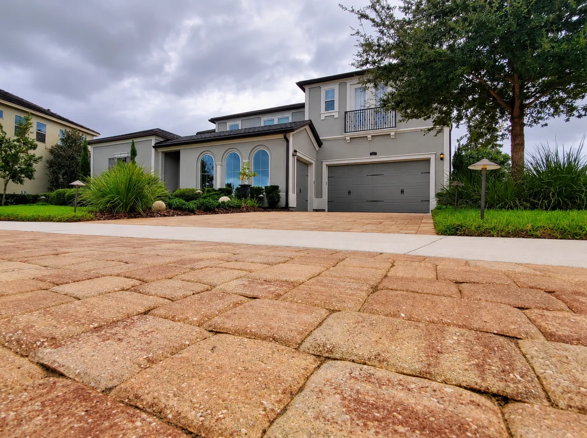 Professional hardscape technicians leveling base aggregate and resetting driveway pavers