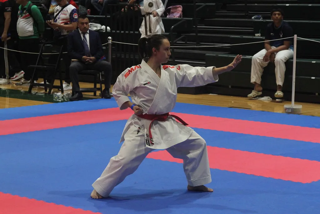 A person in a white martial arts gi tightening a black belt