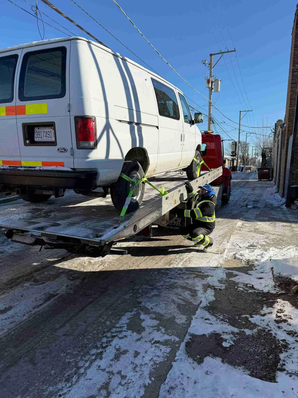 AWD vehicle on a flatbed tow truck, all four wheels off the road