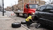 Chicago roadside assistance technician helping stranded motorist on Lake Shore Drive at night